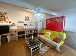 uma sala de estar com um sofá e uma mesa em La casita de los sueños em Casarrubios del Monte