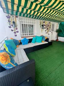 un patio con sofá y césped verde en La casita de los sueños, en Casarrubios del Monte