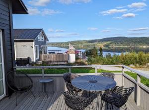 una mesa y sillas en una terraza con vistas al lago en Lovely home by Glomma river!, en Vidnes