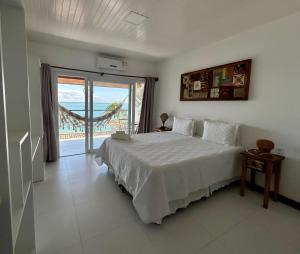 a bedroom with a bed with a view of the ocean at Pousada Aroeira Eco in Morro de São Paulo