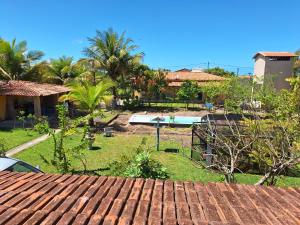 uma vista para um quintal com uma piscina e palmeiras em Casa na Praia com Piscina em Costa Dourada