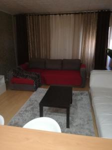 卡帕里卡海岸的住宿－Apartamento Da Costa，客厅配有红色的沙发和桌子