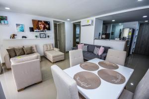 comedor y sala de estar con mesa y sillas en APARTAMENTO OCEAN DRIVE 410 CARTAGENA en Cartagena de Indias