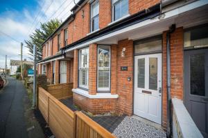 a brick house with a white door on a street at 3 Anzac Cottage in Cowes