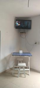 una mesa con un banco y una TV en la pared en Apartamento ideal y acogedor en Mérida