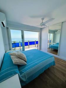 1 dormitorio con cama azul y vistas al océano en ¡Precioso ático frente al mar! en Denia