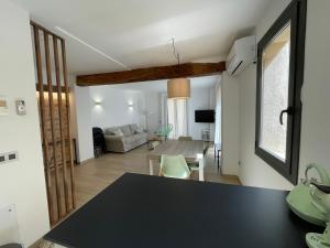 una cucina e un soggiorno con ripiano nero di ROS CENTRIC Cal Ros a Montblanc