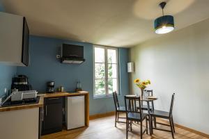 uma cozinha com mesa e cadeiras num quarto em L'Agate Bleue em Saint-Aignan