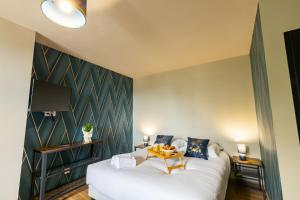 um quarto com uma cama branca e uma mesa em L'Agate Bleue em Saint-Aignan