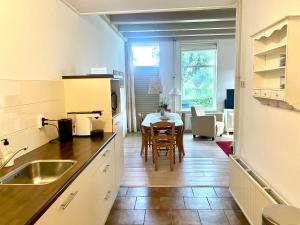 une cuisine avec une table et une salle à manger dans l'établissement Appartement Opa's Huisje, à Ruinerwold