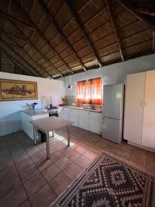 a large kitchen with a table and a refrigerator at Vanross Bushveld Self Catering Accommodation in Maraheki