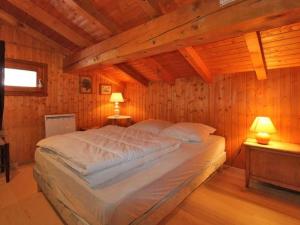 a large bed in a room with wooden walls at Chalet Montvalezan-La Rosière, 6 pièces, 8 personnes - FR-1-398-508 in La Rosière