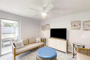 sala de estar con sofá y TV de pantalla plana en Blue Wave Cottage en Jacksonville Beach
