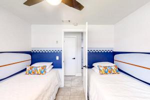 2 camas en una habitación con paredes azules y blancas en Blue Wave Cottage en Jacksonville Beach