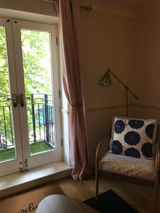 a room with a chair next to a window at Key & Flowers - Kensington Residence 1 in London