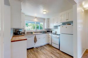 a white kitchen with white appliances and a window at Seabright in Santa Cruz
