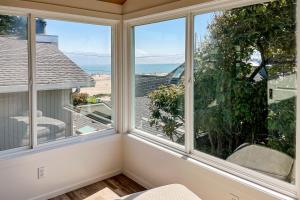 a room with three windows looking out at the ocean at Seabright in Santa Cruz