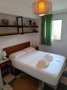 1 dormitorio con 1 cama con toallas en room private bathroom in shared apartment 50m from Gibraltar en La Línea de la Concepción