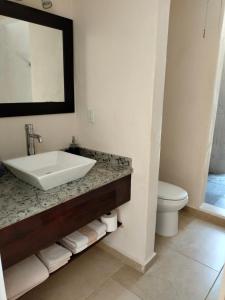 a bathroom with a sink and a toilet at Cabañas Puerto Morelos in Puerto Morelos