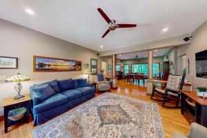 a living room with a blue couch and a ceiling fan at Mountain Cascade in Hague