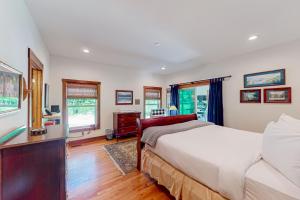 a bedroom with a bed and a dresser and windows at Mountain Cascade in Hague