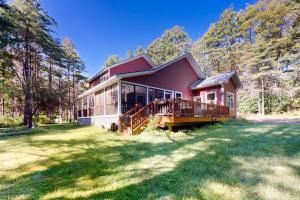 a red house with a large yard in a forest at Mountain Cascade in Hague
