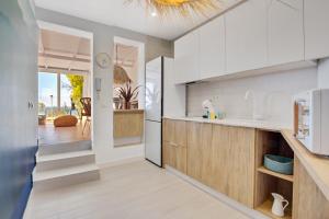a kitchen with white appliances and a dining room at Casa de la Playa. Beach House with magnificent sea in Málaga