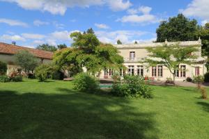 una gran casa blanca con un gran patio en Domaine de Champ rose, en Saint-Laurent-de-Belzagot