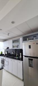 uma cozinha com armários brancos e um frigorífico de aço inoxidável em CASA LUXURY em Villavicencio