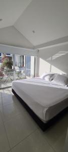 uma grande cama branca num quarto com uma grande janela em CASA LUXURY em Villavicencio