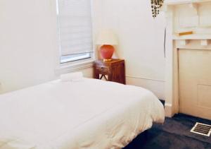 a bedroom with a white bed and a window at Oui on Ludlow - Entire House and Private Rooms in University City in Philadelphia