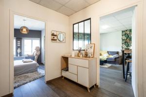 una camera con letto e scrivania con specchio di Charmant logement Villefranche a Villefranche-sur-Saône
