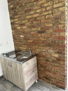 a brick wall with a wooden chest next to a brick counter at SOBE ŠPONGA in Kikinda