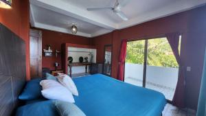 - une chambre avec un lit bleu et une fenêtre dans l'établissement Villa frente al mar en Yelapa para 4 personas, à Yelapa