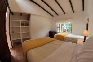 a bedroom with two beds and a window at Casa La Picaza in Villa de Leyva