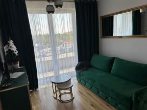 a living room with a green couch and a table at Brand New !!! Baltic Marina Residence Sauna & Fitness Apartments- Royal Green Apartments, Ferienwohnung polnische Ostsee in Kołobrzeg