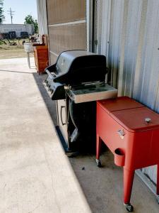 a grill sitting on the side of a building at In A Meading - Safari Tent - BeeWeaver Honey Farm in Navasota