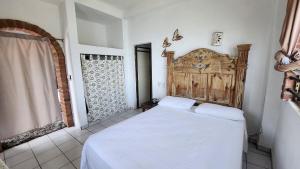 a bedroom with a large white bed and a window at Villa frente al mar en Yelapa para 2 personas in Yelapa