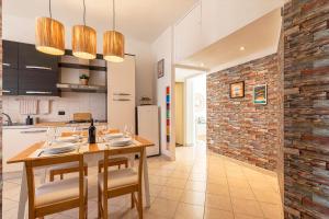 a kitchen with a wooden table and chairs and a brick wall at MiCo Apartment in Fiera Milano City in Milan