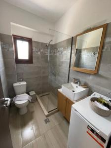 a bathroom with a toilet and a sink and a shower at Olivar Suites in Palekastron