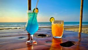 two drinks sitting on a table at the beach at Refugio Sova in Jama