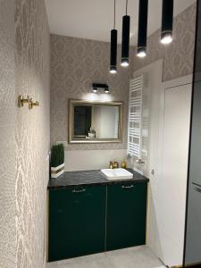 a bathroom with a green sink and a mirror at Brand New !!! Baltic Marina Residence Sauna & Fitness Apartments- Royal Green Apartments, Ferienwohnung polnische Ostsee in Kołobrzeg