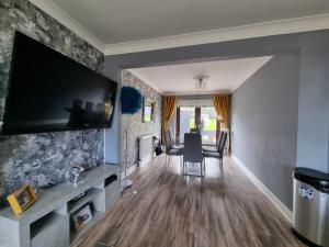 a living room with a large flat screen tv on a wall at Private room City skyline and mountain views close too belfast centre and airports free parking in Belfast