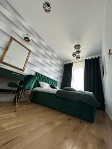 a bedroom with a green bed and a mirror at Brand New !!! Baltic Marina Residence Sauna & Fitness Apartments- Royal Green Apartments, Ferienwohnung polnische Ostsee in Kołobrzeg