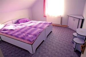 a bedroom with a bed and a table and chairs at Kristóf kulcsosház in Gheorgheni