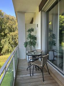 d'une terrasse avec une table et des chaises sur un balcon. dans l'établissement Appartement du golf du lys Insolys, à Gouvieux