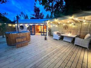 a deck with a hot tub and a table and chairs at The Pines Treehouse at Treetops Hideouts in Richmond