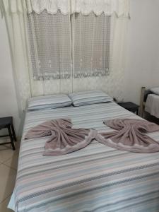 1 dormitorio con 2 camas y cortinas blancas en Casas do Rodrigo, en Santana do Riacho