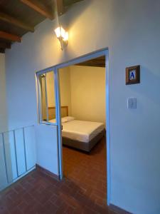 巴里查拉的住宿－Flor de León Café - Hostal，一间卧室设有一张床和一个玻璃门廊