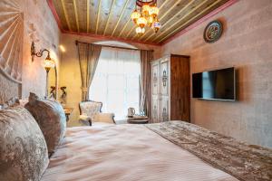 1 dormitorio con 1 cama grande y TV en CAPPANAR CAVE HOTEL en Nar